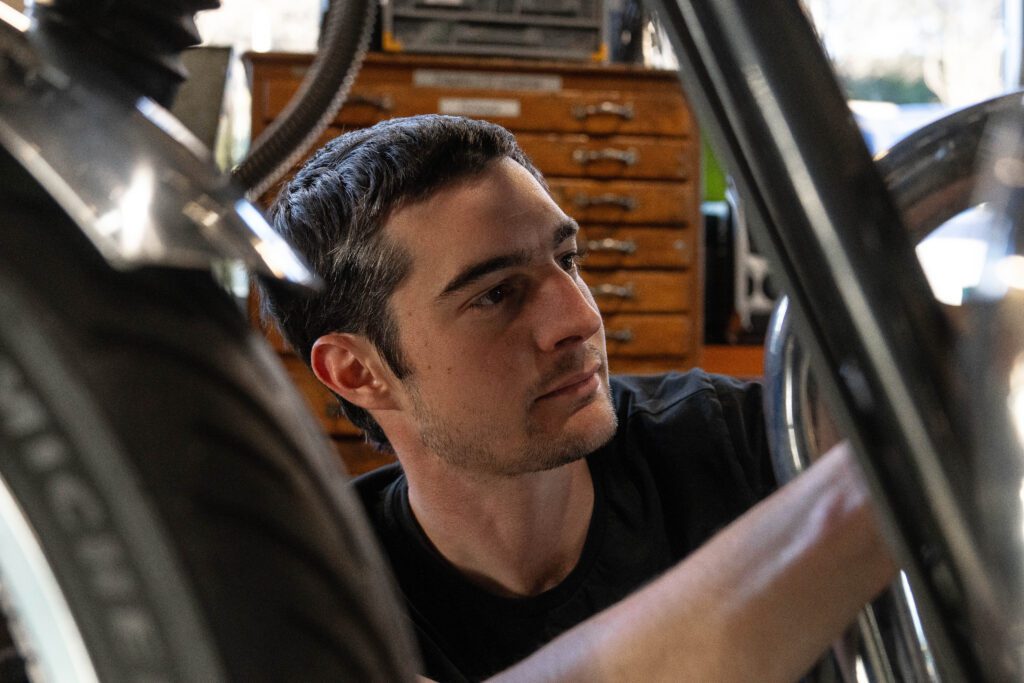 gros-plan-d-un-mecanicien-concentre-en-train-de-reparer-une-moto-dans-l-atelier-de-pmh-motos